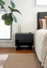 By Carmont Aman floor rug in Sandstone in a bedroom beside a dark timber bedside table