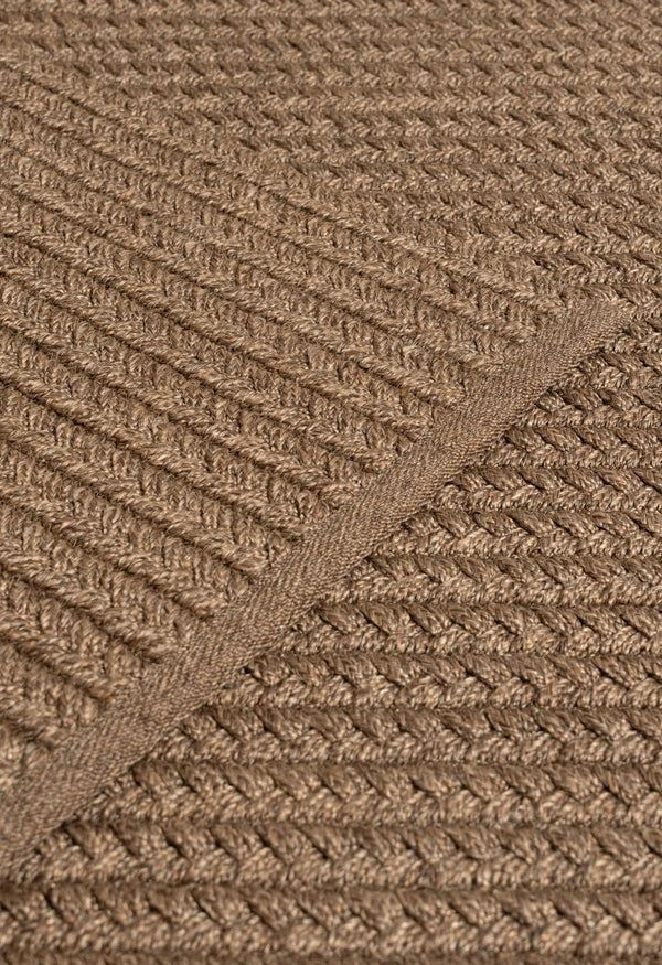 By Carmont Aman Floor Rug in Topaz, close-up of the weave with the binding edge across the diagonal