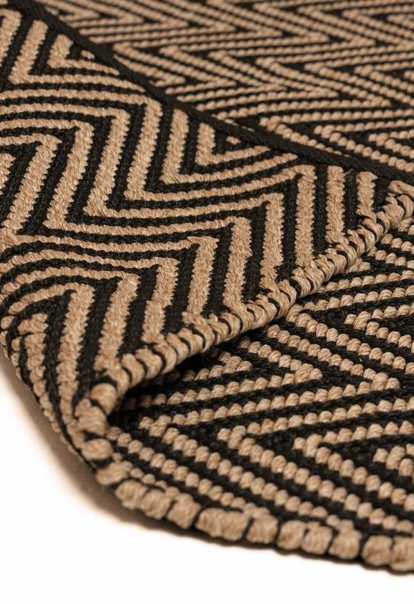 By Carmont Bhumi Floor Rug in Seraphic, folded corner showing the woven edge binding