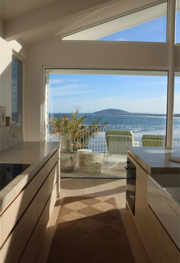 By Carmont Capella runner in Natural in a kitchen with ocean views through floor-to-ceiling windows