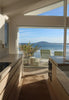 By Carmont Capella runner in Natural in a kitchen with ocean views through floor-to-ceiling windows