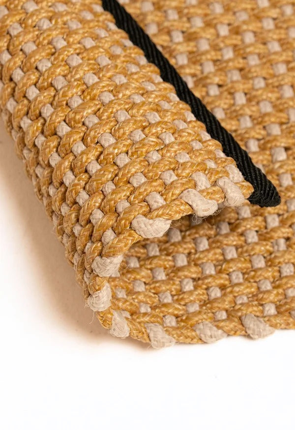 By Carmont Chase floor rug in Honeysuckle, corner fold detail showing the woven texture and edge binding