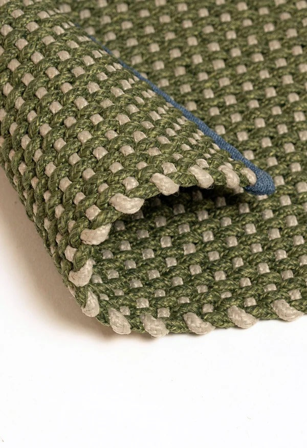 By Carmont Chase floor rug in Seagrass, corner fold detail showing the woven texture and blue edge binding