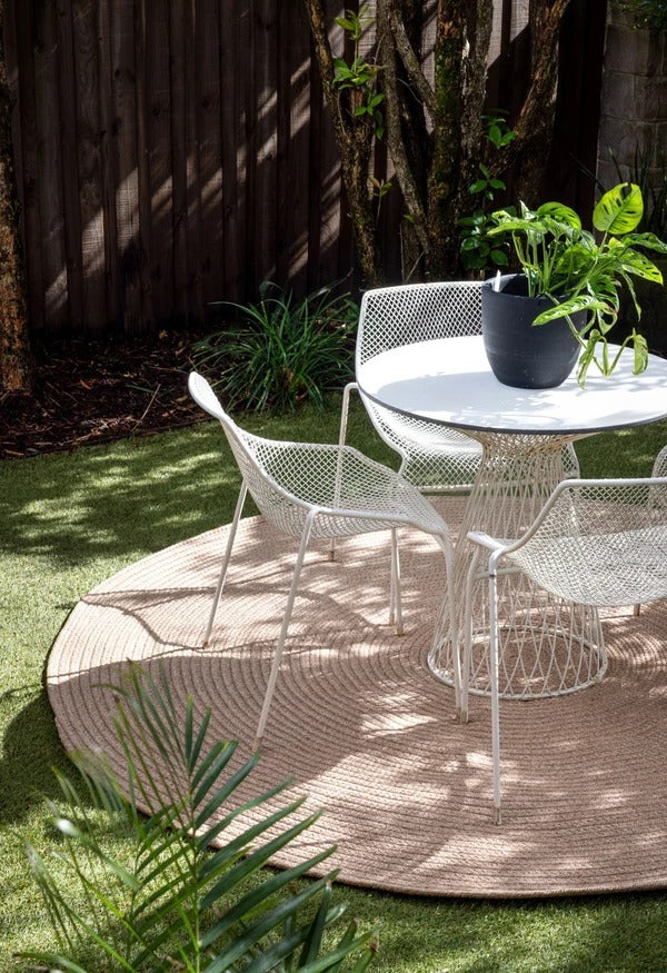 By Carmont Grange Floor Rug in Natural, round rug styled in an outdoor courtyard setting
