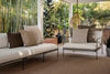 By Carmont Huxley cushion cover in Cameo on an outdoor sofa with brown and tan cushions, beside an armchair