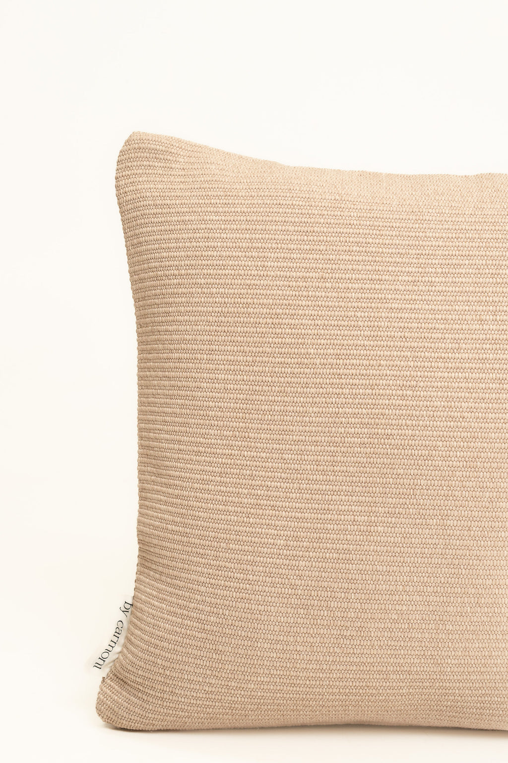 By Carmont Wren cushion cover in Cameo, corner close-up showing the woven texture and brand label