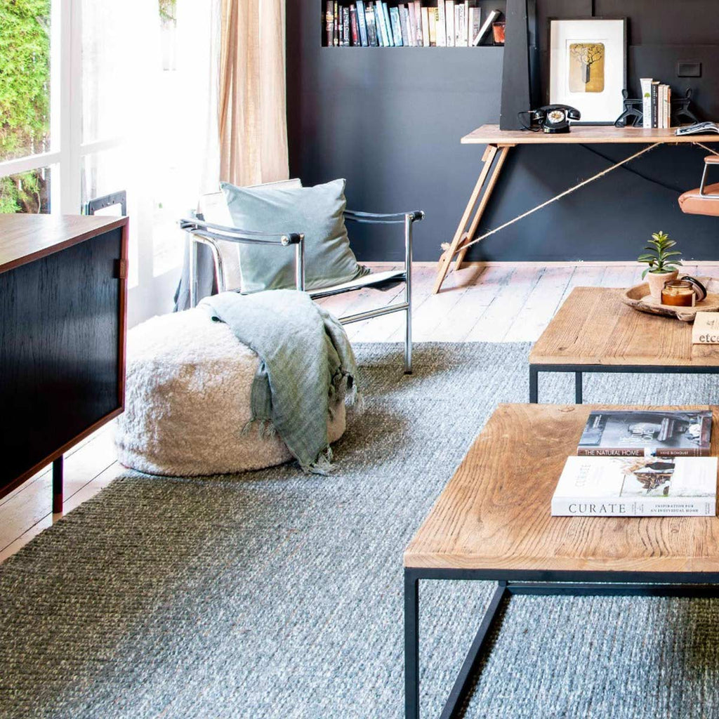 A stylish, bohemian style living room with a sage green wool and jute boucle woven floor rug. 