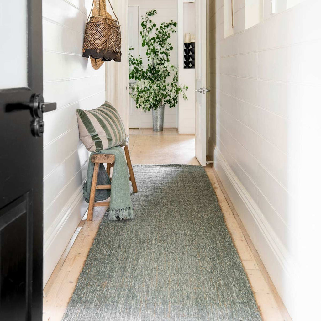 A hallway with a natural textured green runner down the middle, made with a blend of wool and jute fibres. 
