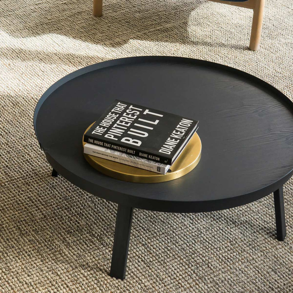 A coffee table, atop a stylish textured floor rug hand woven with cream wool and natural brown jute fibres. 