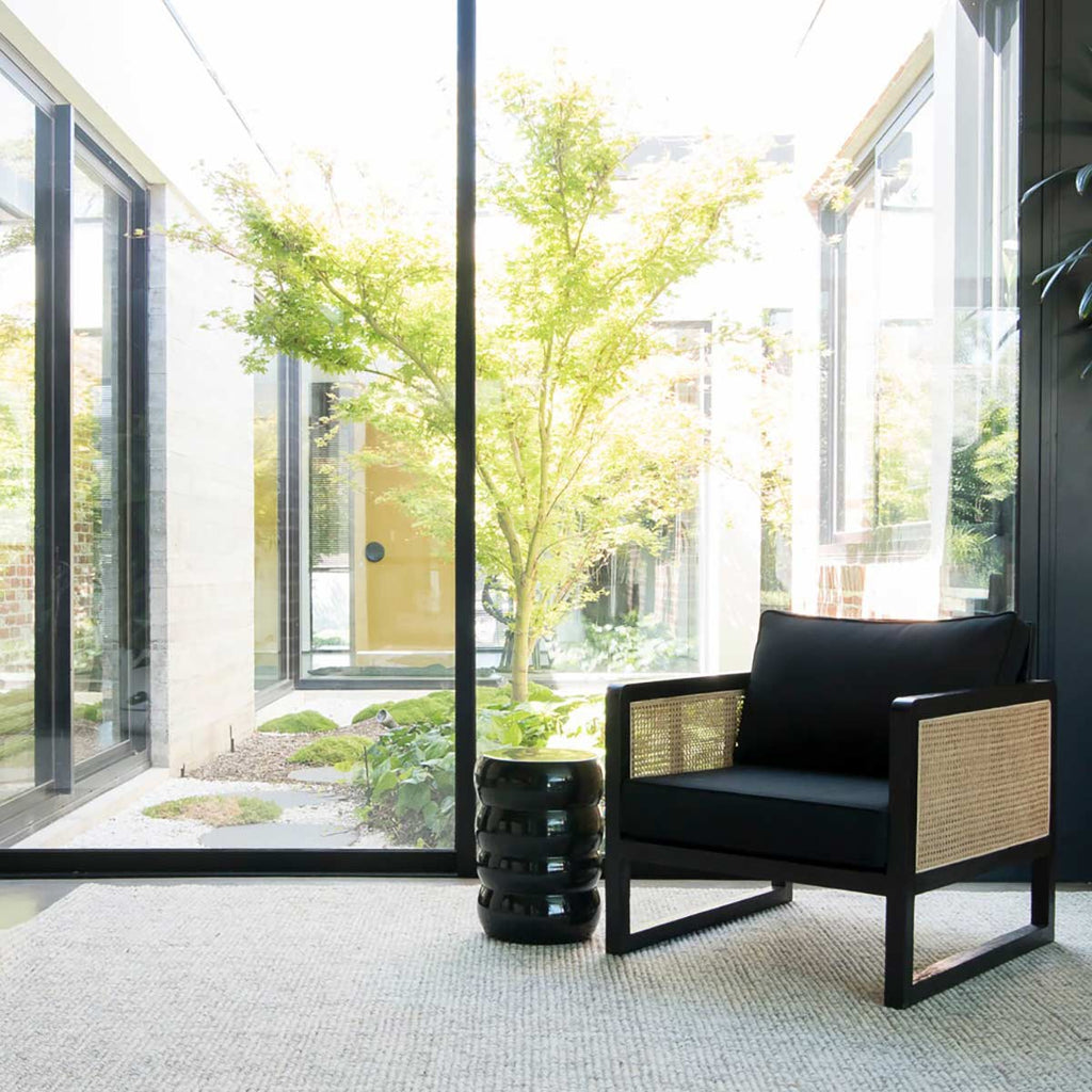 A modern style living room, with a warm neutral toned floor rug in wool and jute. 