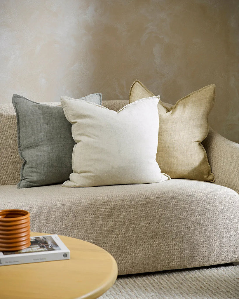 A contemporary living room featuring three Baya linen cushions