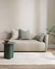 Baya square linen cushion in colour sage green, shown with Arcadia Sage lumbar and a cream cushion in a modern living room setting