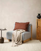 Pale brown 'taupe' cotton throw blanket draped on a chair in a modern home