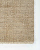 A corner image from above of the Corbett floor rug in the shade Honey, a lightly distressed contemporary warm beige, with cream detailing and a short creamy fringe. By Baya