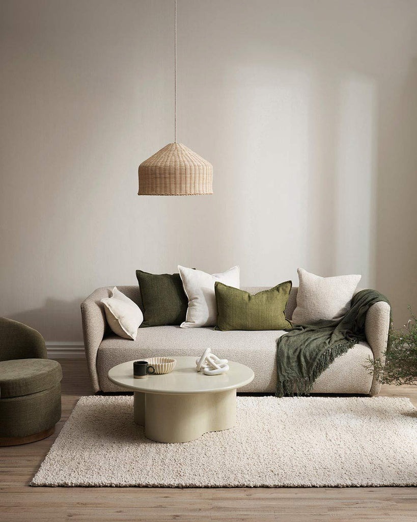 A modern NZ living room featuring olive green and cream toned cushions