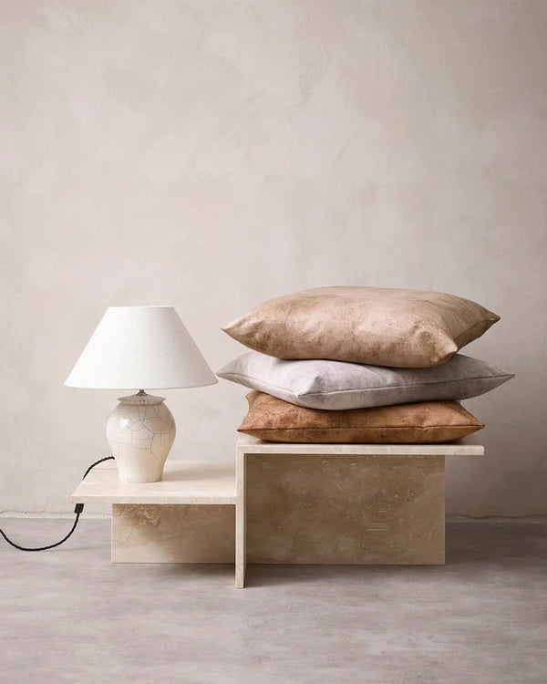 Pile of Baya Theo velvet cushions in a modern home