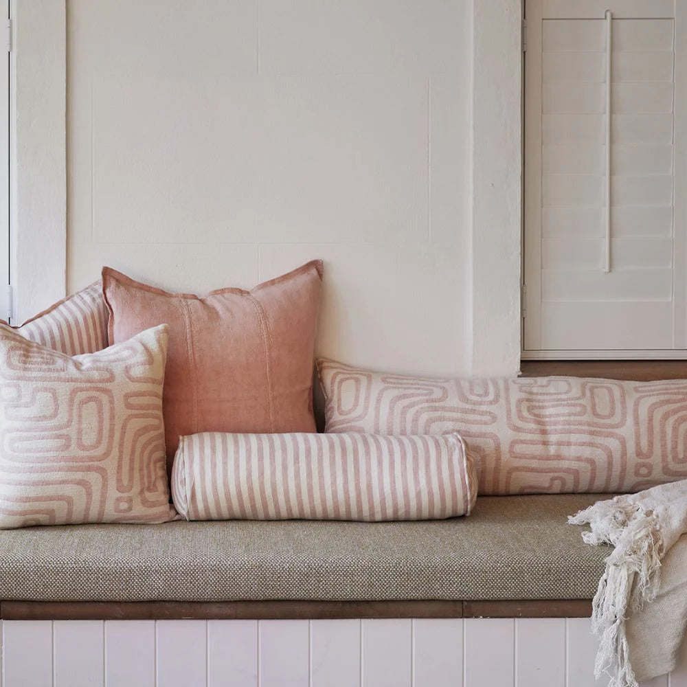 Eadie Lifestyle Drift bolster in White/Soft Musk styled on a window seat with linen cushions in soft pink tones