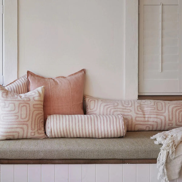 Eadie Lifestyle Drift bolster in White/Soft Musk styled on a window seat with linen cushions in soft pink tones