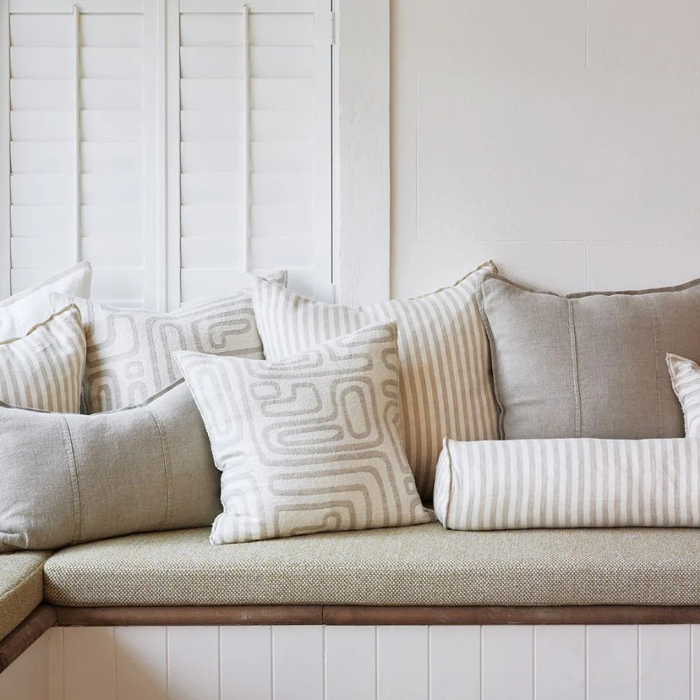 Eadie Lifestyle Drift cushion in White/Natural styled on a window seat with linen cushions in natural tones