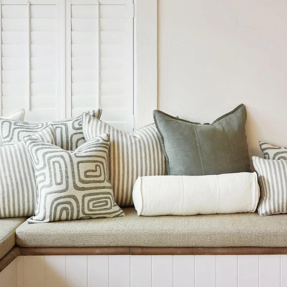 Eadie Lifestyle Drift cushion in White/Pistachio styled on a window seat with linen cushions in soft green tones