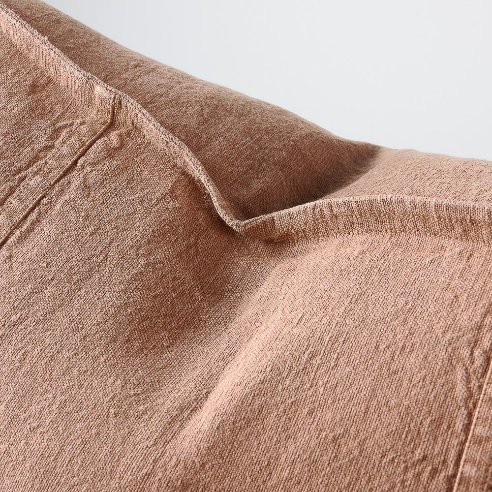 Close view of the washed linen weave and panel seam on the Luca cushion in Clay.