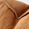 Close view of the washed linen weave and flange edge on the Luca cushion in Nutmeg.