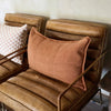 Eadie Lifestyle Luca linen cushion in Nutmeg in the 40 x 60cm size on a tan leather chair.