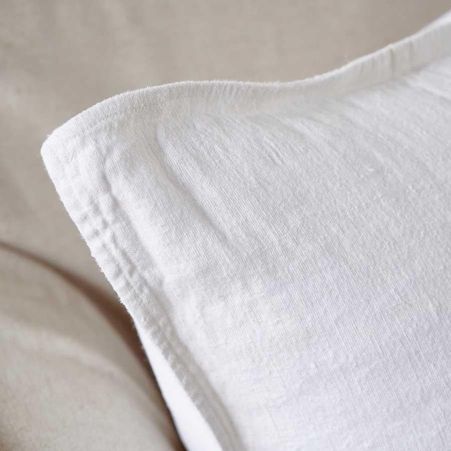 Close view of the flange edge and corner on the Luca cushion in Off White.