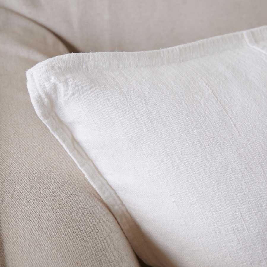 Close view of the washed linen edge and seam on the Luca cushion in Off White.