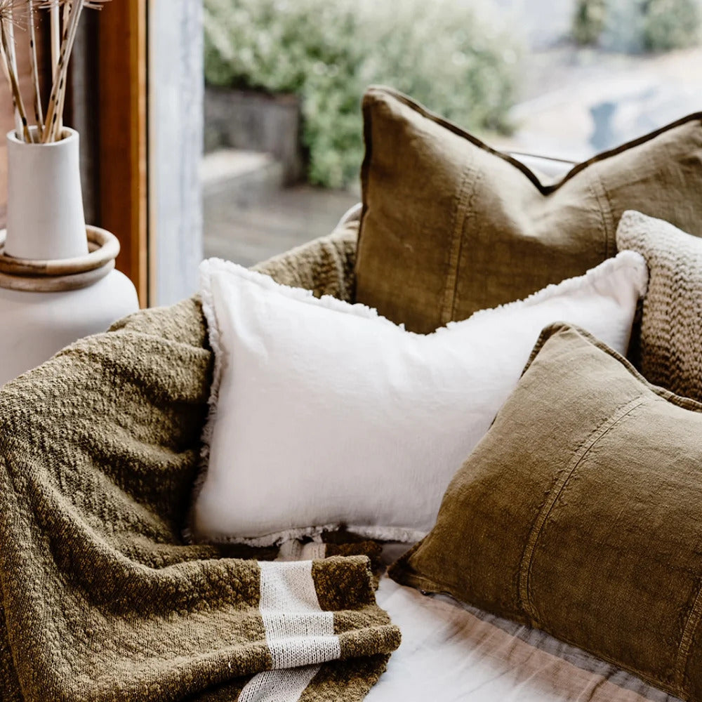 Eadie Lifestyle Luca linen cushions in Olive on a daybed with a knitted throw.