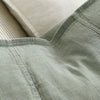 Close view of the washed linen weave and flange edge on the Luca cushion in Pistachio.
