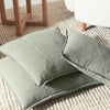 Two Eadie Lifestyle Luca linen cushions in Pistachio resting on a woven jute rug.