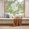 Eadie Lifestyle Luca linen cushion in Sky on a window seat with a rust throw.