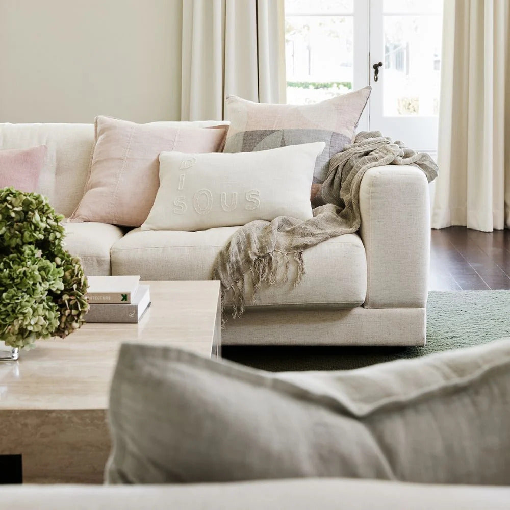Eadie Lifestyle Luca linen cushion in Soft Lilac on a linen sofa with a soft throw.