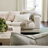 Eadie Lifestyle Luca linen cushion in Soft Lilac on a linen sofa with a soft throw.