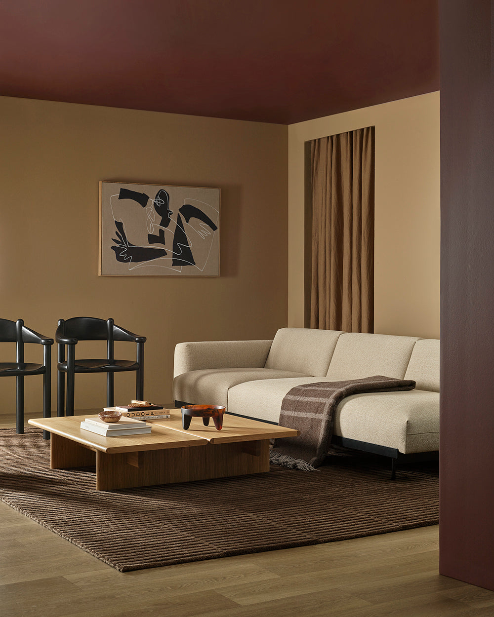 Modern living room with a beige sofa, wooden coffee table, large brown wool throw and brown rug