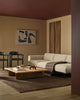 Modern living room with a beige sofa, wooden coffee table, large brown wool throw and brown rug