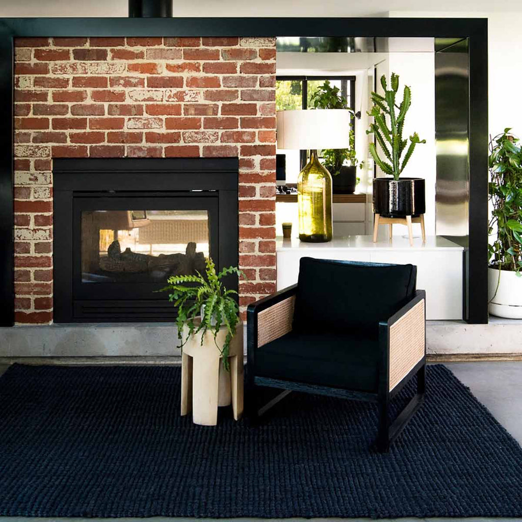 A sophisticated sitting area with a black jute textured floor rug. 