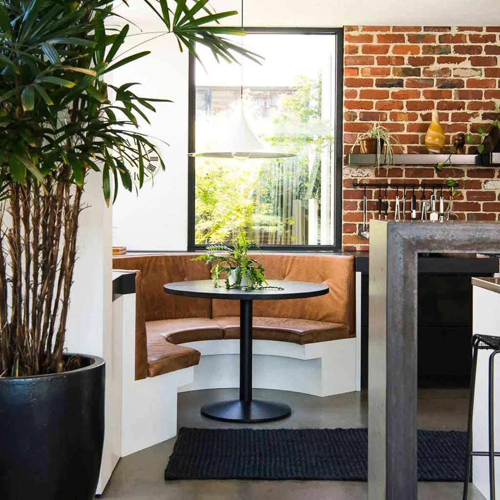A kitchen table bar area with a black jute floor runner 