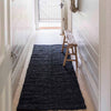 A hallway runner made of textural black jute in a bold boucle style. 