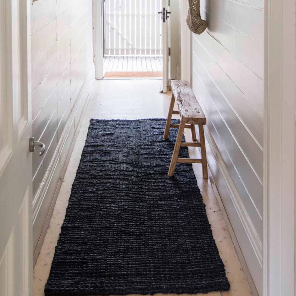 A hallway runner made of textural black jute in a bold boucle style. 