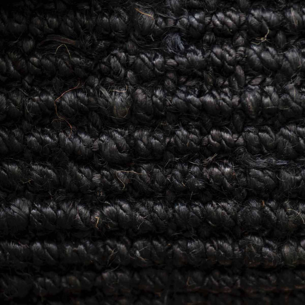 A close up of the textured weave of the Black graphite jute floor rug collection. 