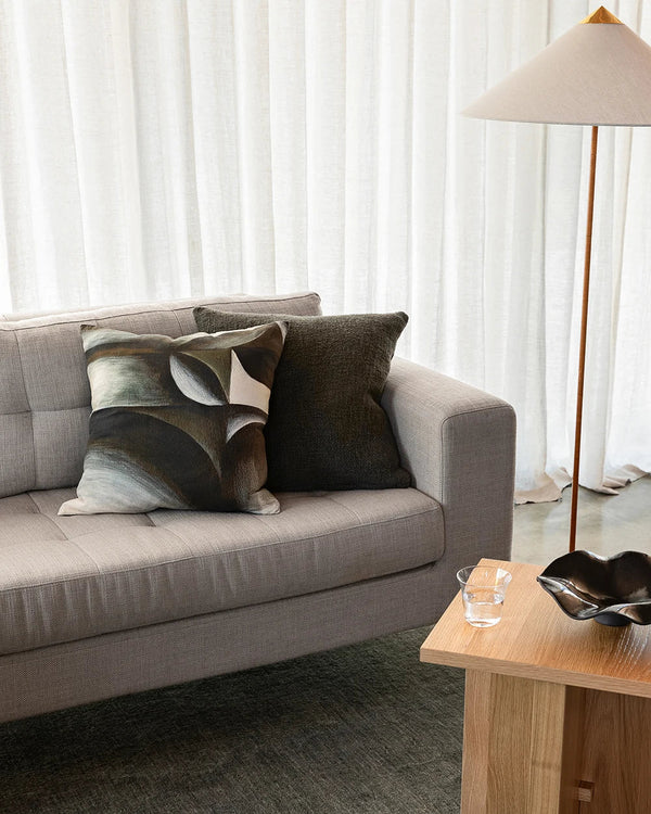 Dark green Baya cushions on a couch in modern living room