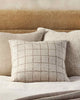 Baya designer cushions in natural linen-look and taupe, inspired by Japanese design, seen together on a  modern bed