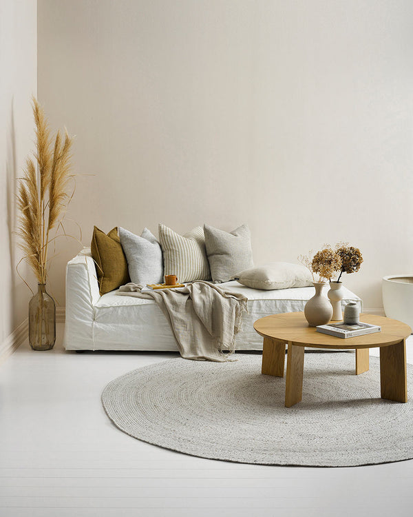A modern living room, styled in warm pale tones. An indoor/outdoor rug by Baya NZ in shade Pale Sand is on the floor. 
