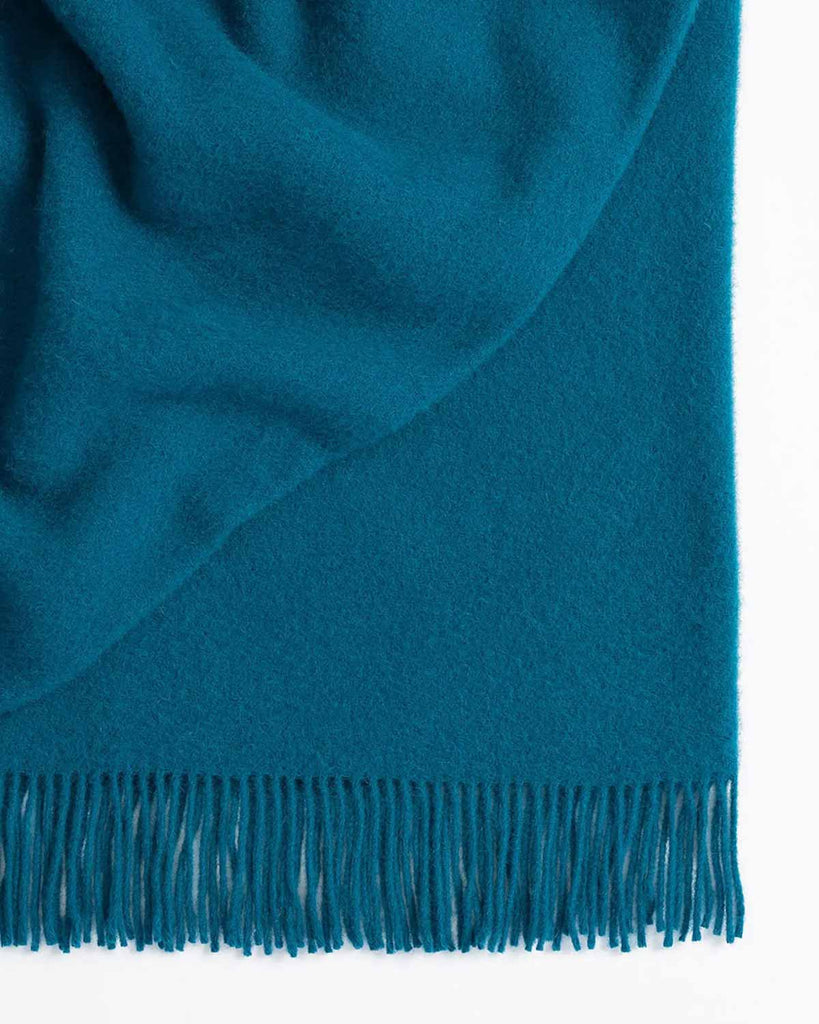 A bright blue lambswool throw blanket by Weave Home.