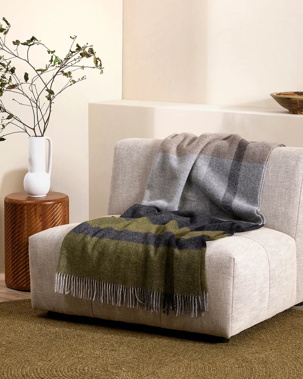 Baya nz wool throw plaid throw blanket in grey, charcoal and green, drpaed over chair in contemporary nz home