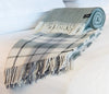 Palliser Ridge Herringbone throw in Forest, rolled and styled on a bed
