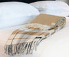 Palliser Ridge Herringbone throw in Mustard, rolled and styled on a bed