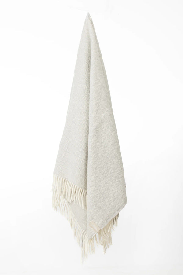 Palliser Ridge Herringbone throw in Dove Grey hanging in full drape, showing the fringed edge